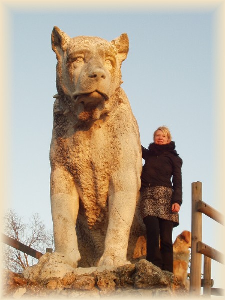 Solveig Burauen steht neben einer übergroßen Hundestatue. Der Ausdruck des Hundes vermittelt den Eindruck eines verlässlichen Partners.